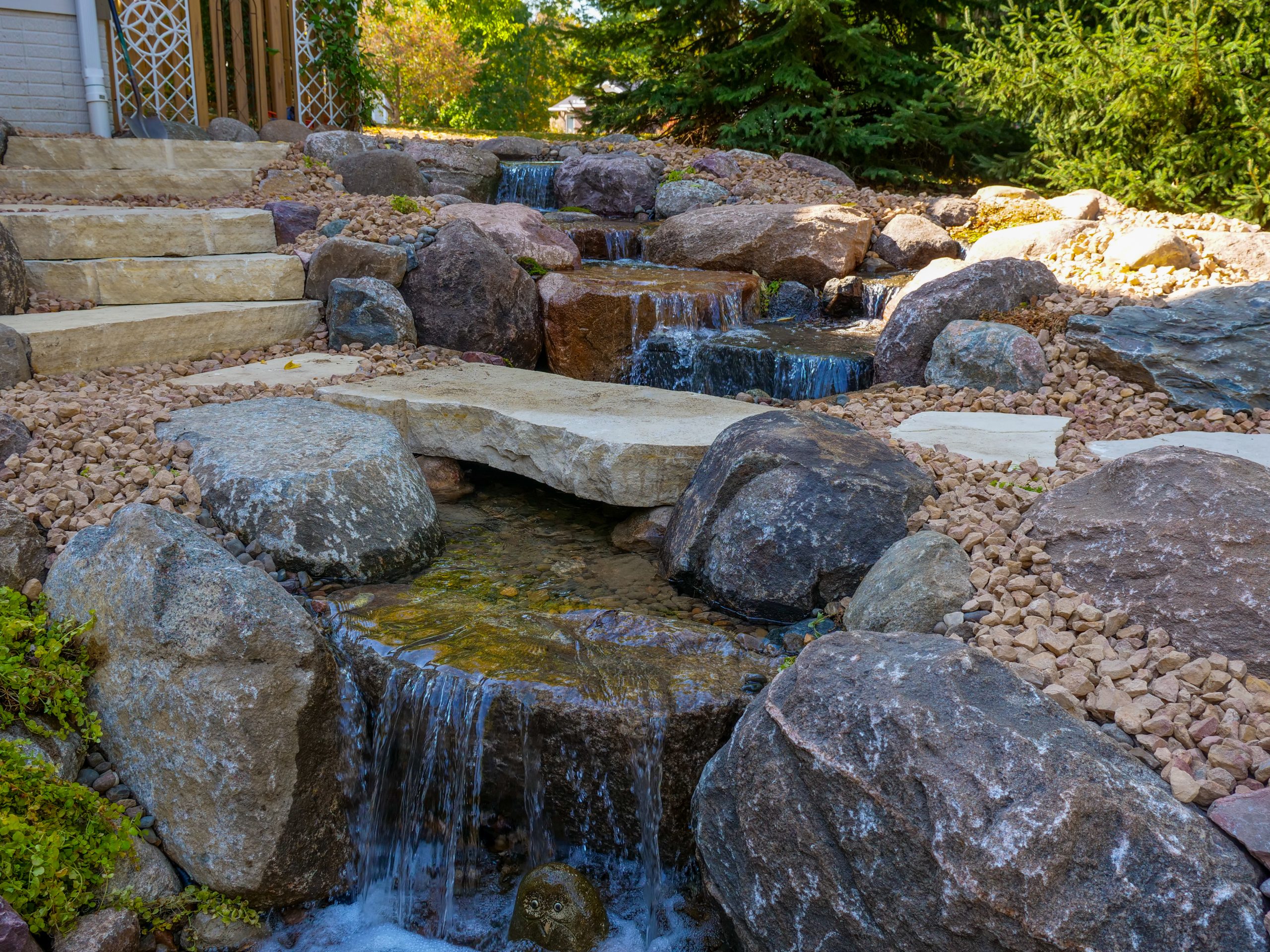 The same backyard after a pondless waterfall was installed